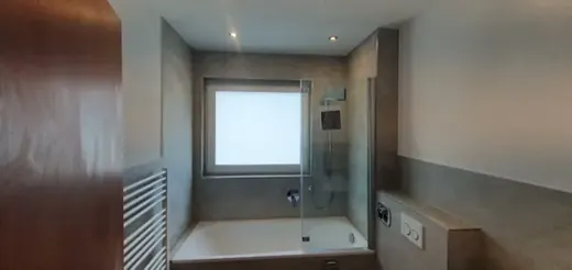Fitted bath, glass shower screen, towel radiator and tiled room