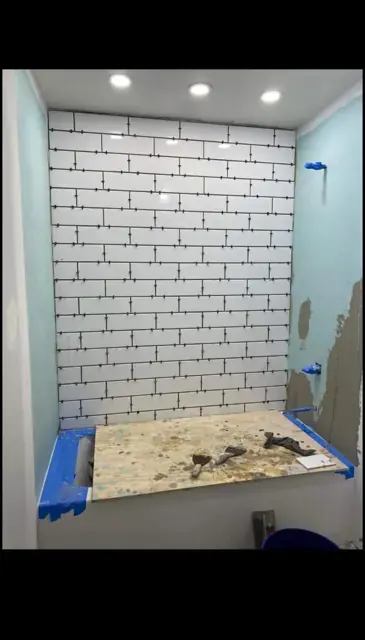 White subway bath-surround tiling with spacers, covered bath and adjacent unfinished walls