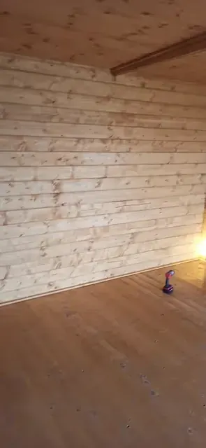 Warm-toned flooring in a timber-panelled room during finishing