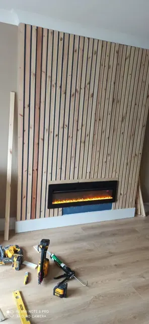 Slatted fireplace wall installation with finishing work underway