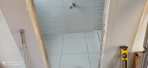 Grey tiled bathroom walls and floor during installation