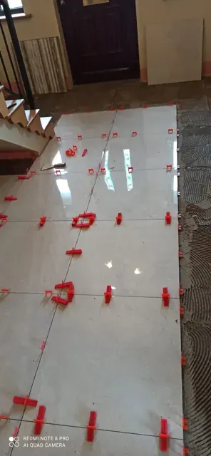 A closer view of white floor tiles with levelling clips