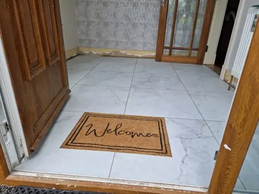 Light large-format tiles across a completed entrance