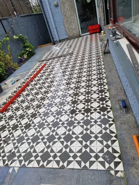 Black and white patterned floor tiles during installation